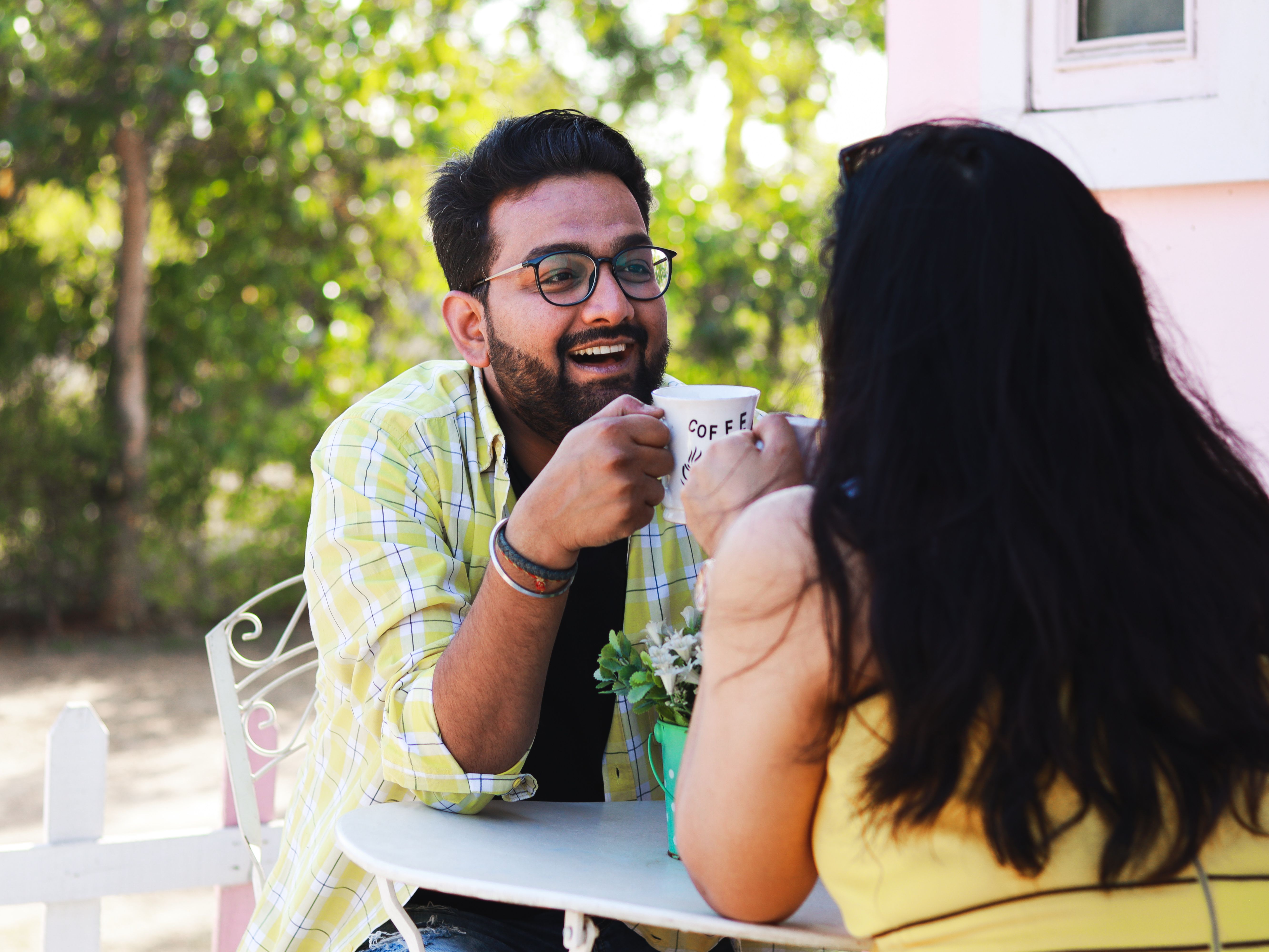 Un couple souriant partage un café à une terrasse
